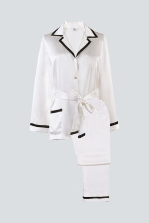 Flat lay of ivory Coco Lady Pajama Set with black trim, showing timeless tailored elegance.