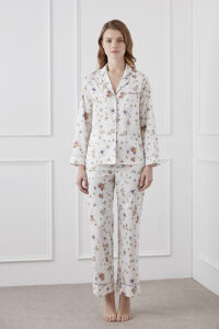 Model wearing a Lrisette Silk Pajama Set featuring a delicate white floral design against a soft background.