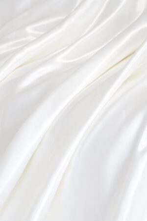 Close-up of Gleam Silk Quilt, smooth white silk surface falling in soft folds for a cloud-like feel.