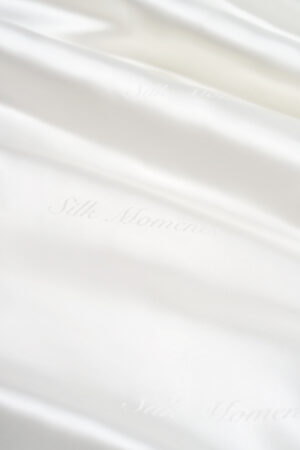 Detail of Gleam Silk Quilt jacquard, with "Silk Moments" subtly woven into the luminous white silk.